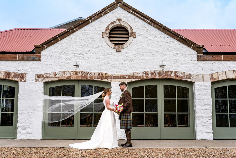 Bride and groom in front of Kinclune Steading